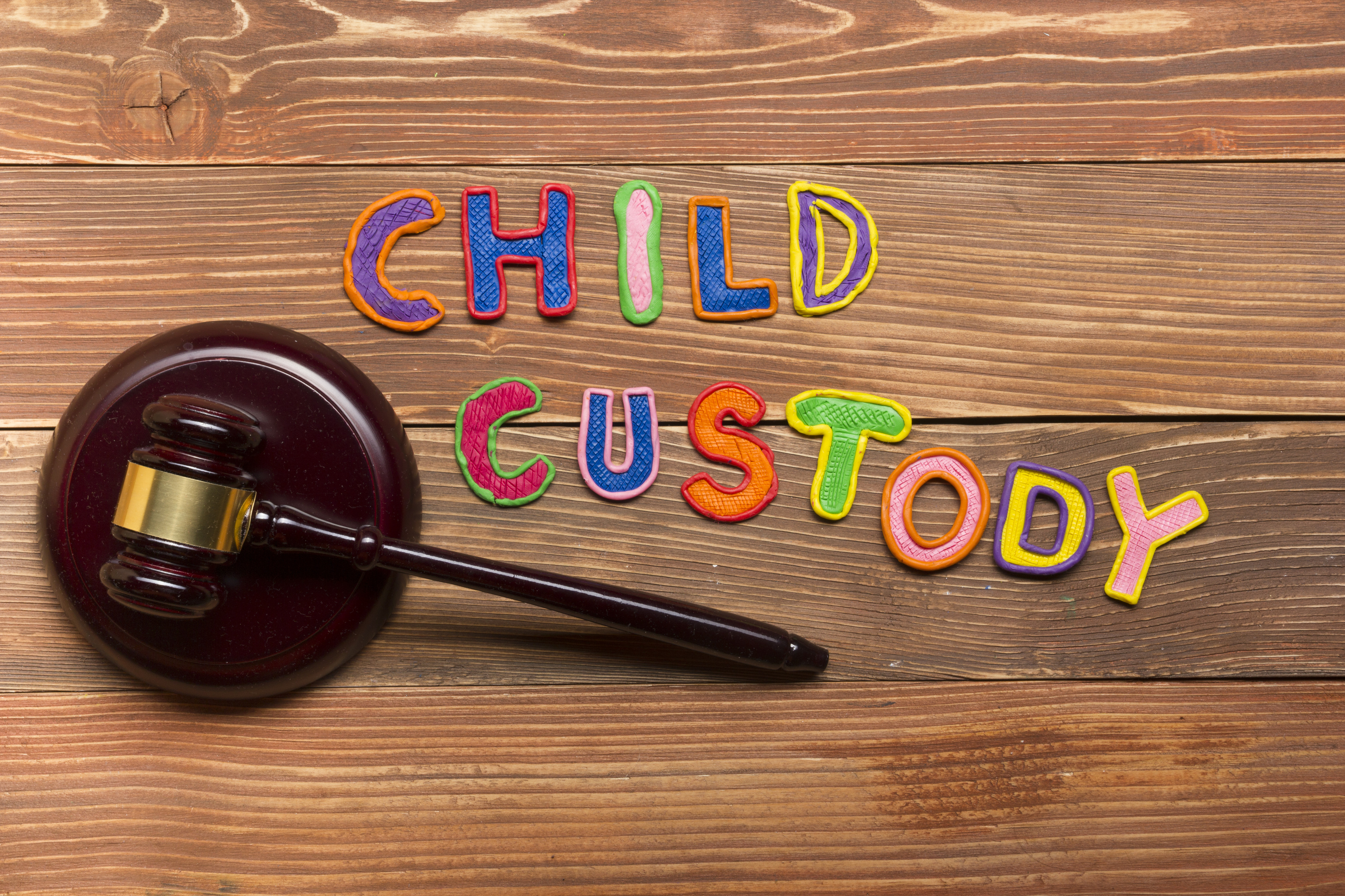 A gavel with the colorful words "child custody" spelled out next to it