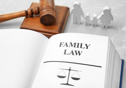 A law book, gavel and wood figures of a family, representing a family law attorney in Pekin IL