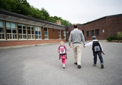 A father taking his two children to school in East Peoria IL
