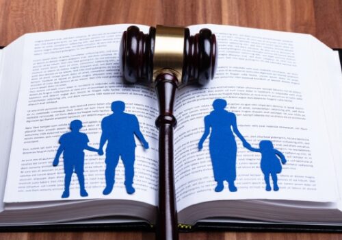 An open book with a cutout of a family separated by a gavel, representing Family Law in Peoria IL