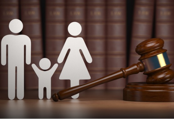 A cutout of a man and a woman with a child in between them next to a gavel, representing Divorce Lawyers in East Peoria IL
