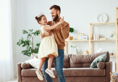 father and daughter in their living room laughing