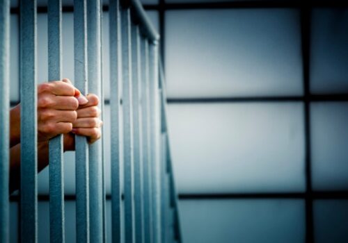 person behind bars in jail