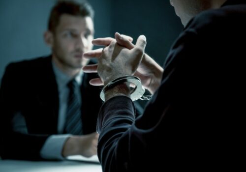 Handcuffed Man Talking to a Pekin IL Criminal Lawyer