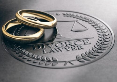 Two wedding rings sitting on an emblem for a Pekin IL Divorce Attorney
