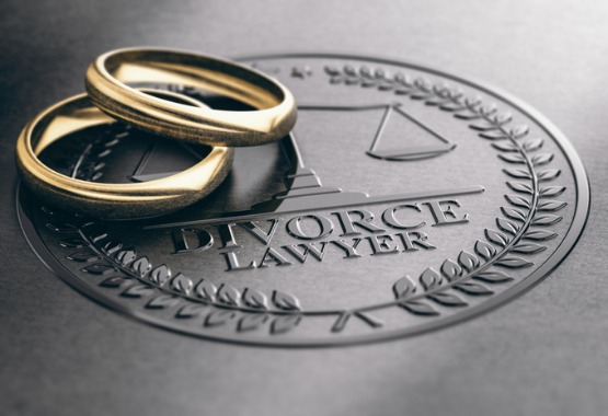 Two wedding rings sitting on a leather folder with a logo for a divorce lawyer in Peoria IL