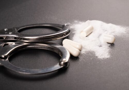 Handcuffs and crushed pills Drug Crimes in East Peoria IL