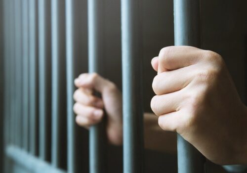 A man behind bars, needing legal assistance from a criminal attorney in Central Illinois