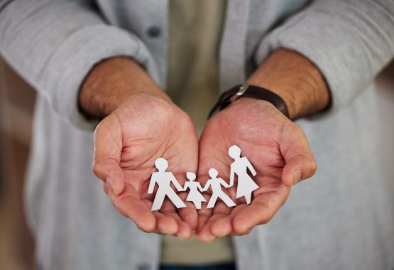 A man holding a paper family in his hands, representing his family and family law