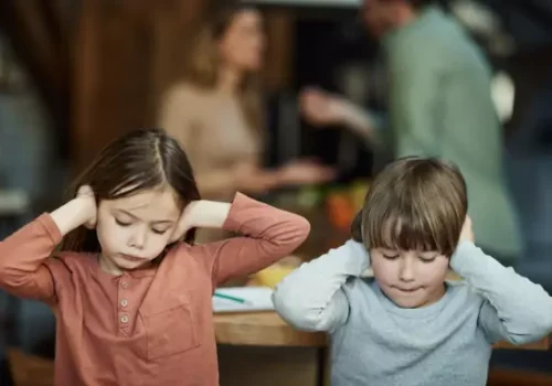 A brother and sister cover their ears as they listen to their parents fight. If you need a lawyer for a Divorce in Pekin IL, Borsberry Law is here to help.
